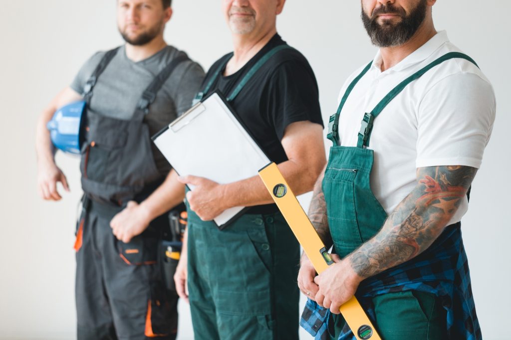 Group of three builders preparing for remodeling of the apartment